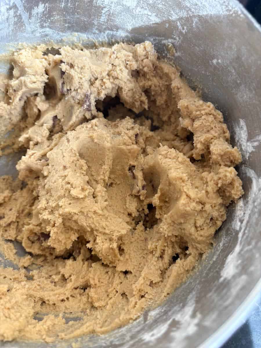 A silver bowl of chocolate chip cookie dough.