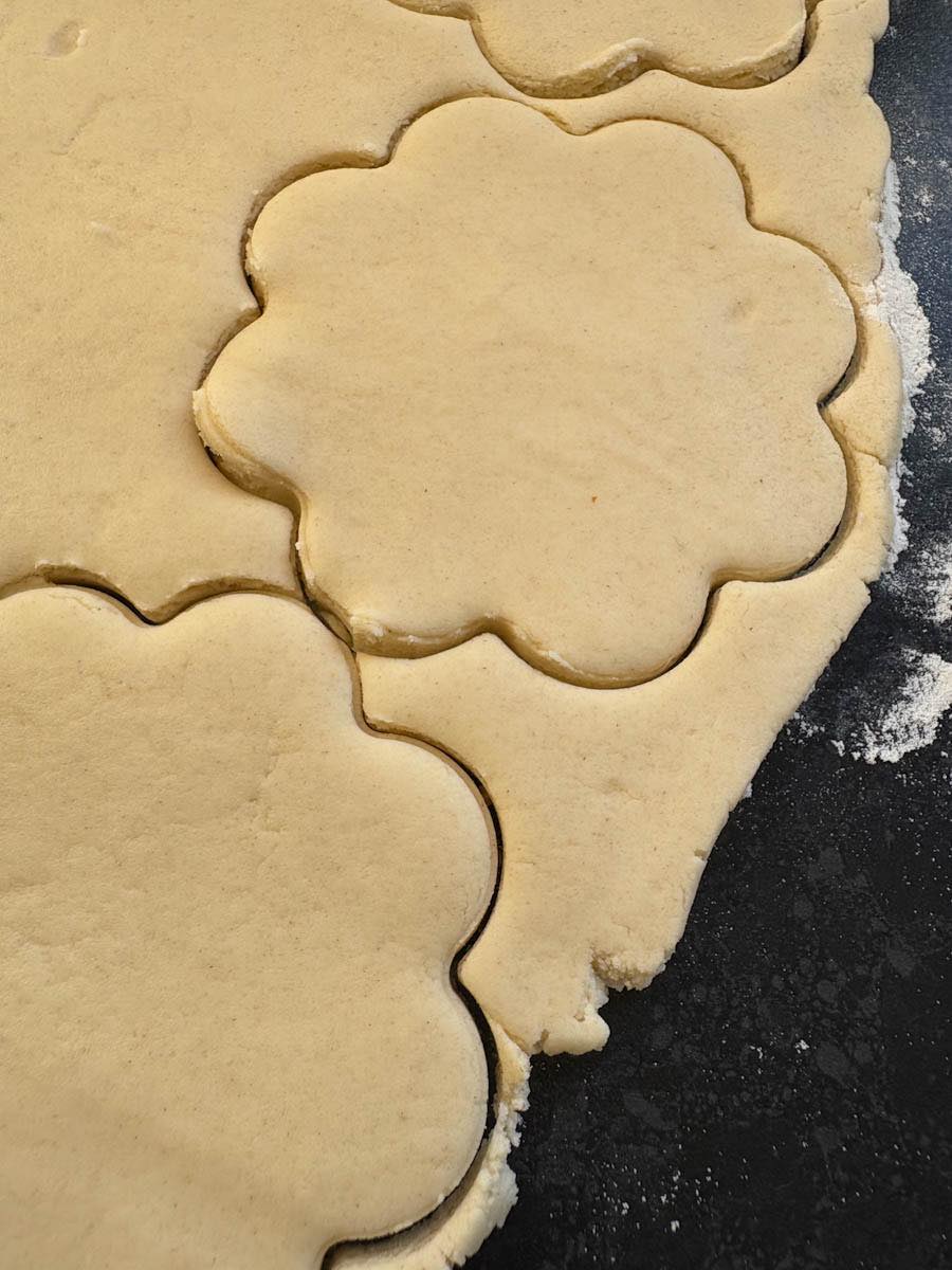 Shortbread dough rolled out and cut into large flower shapes.
