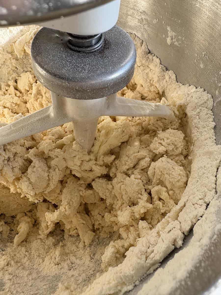 Soft butter, sugar and flour being mixed together in a Kitchen Aid mixer.