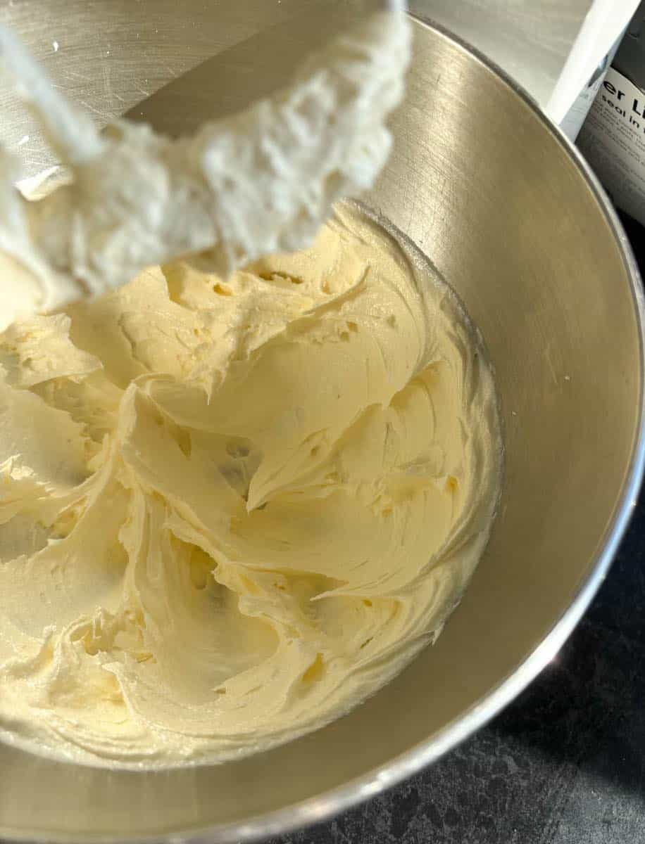 A silver mixing bowl of creamed butter and sugar.