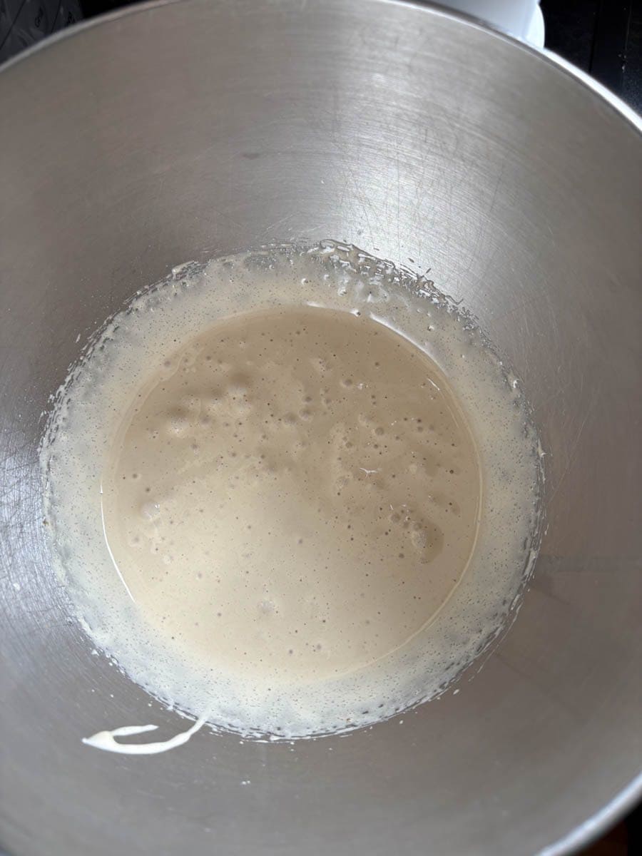 A silver bowl of whisked eggs and sugar.