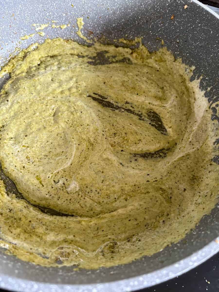 A grey pan of creamy pesto sauce.