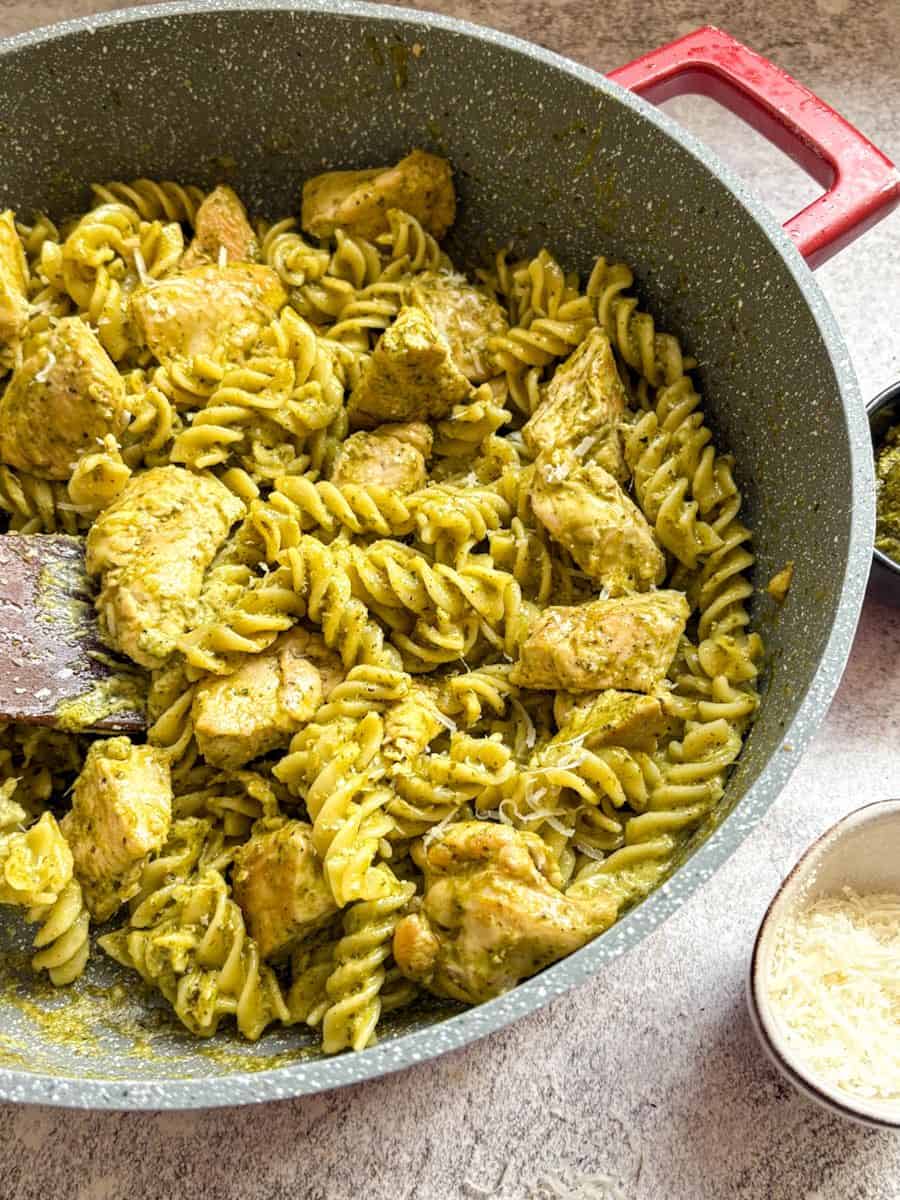 A grey pan of chicken pesto pasta.