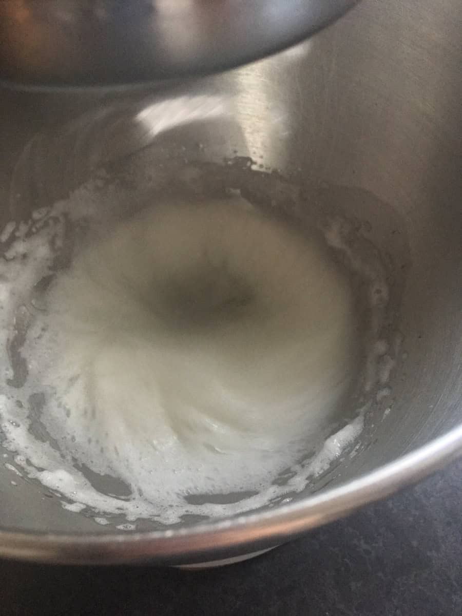 A silver bowl of whisked egg whites.